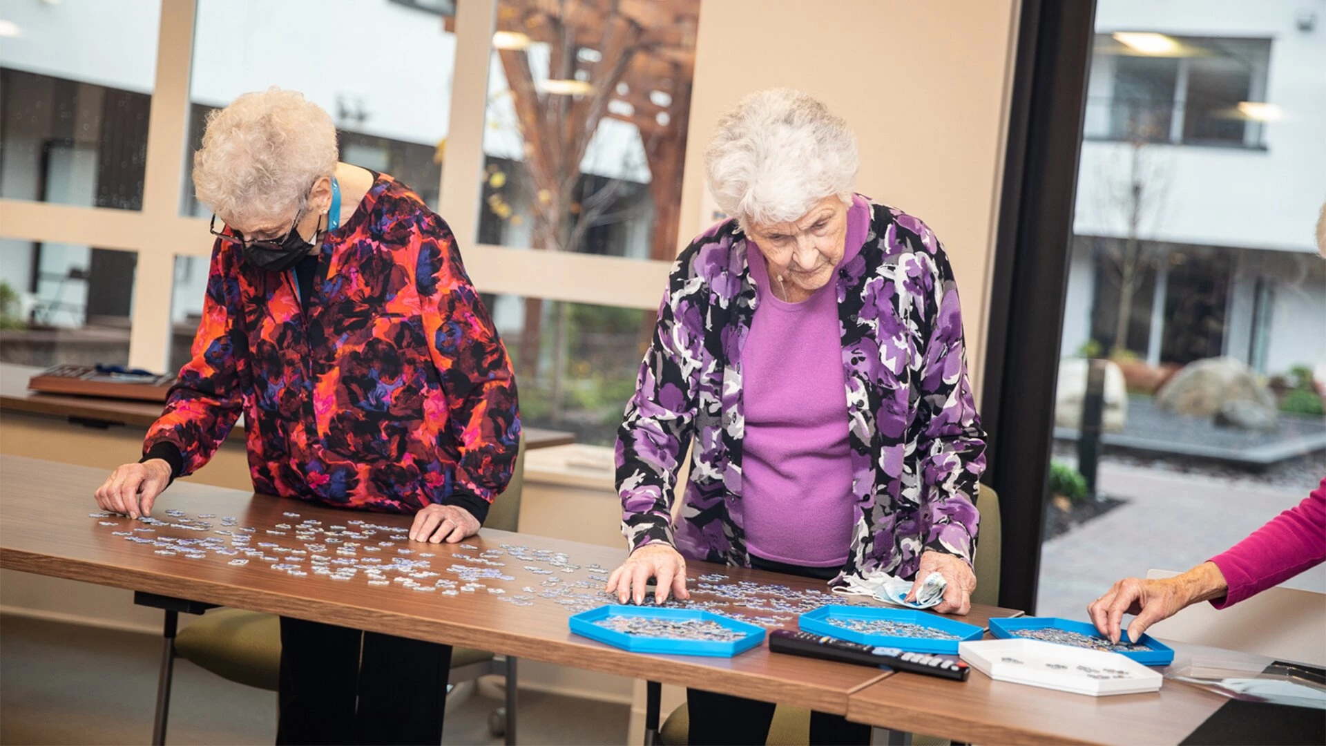Elderly women putting together a puzzle in senior living