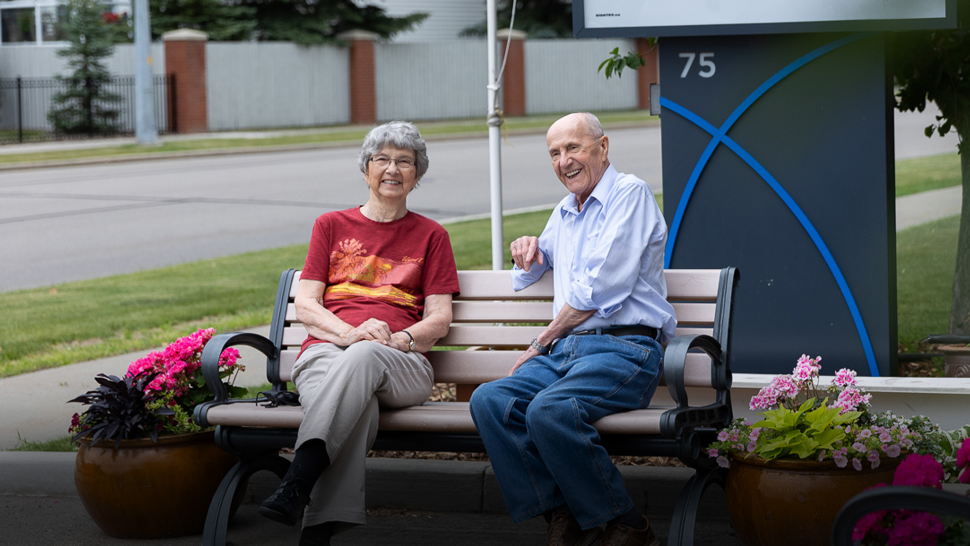Two seniors seated on a bench together