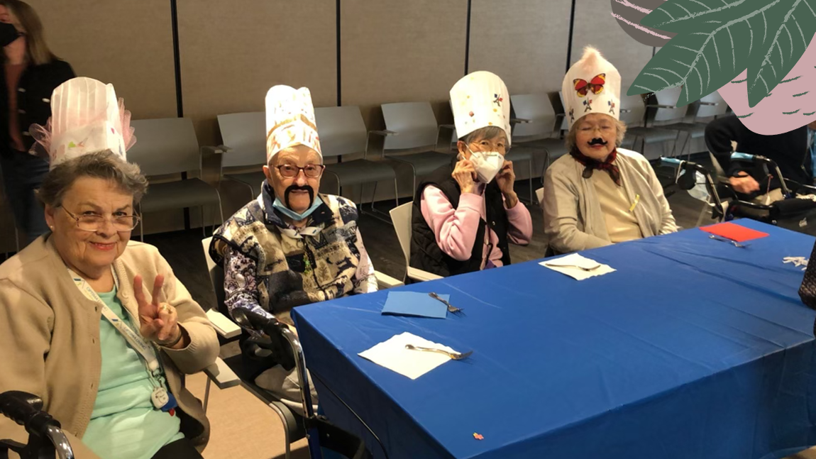 Seniors wearing decorated chef hats in senior living