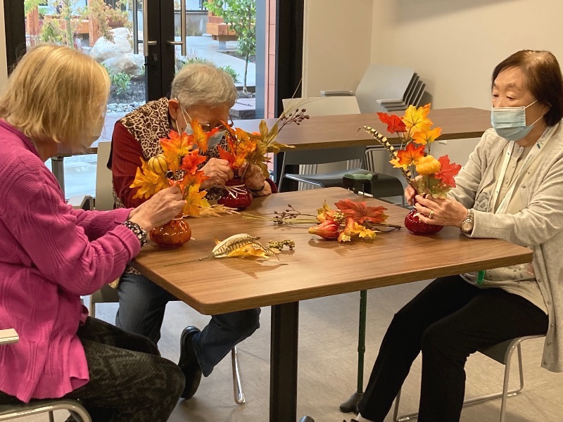A group of senior citizens making artificial flower pots, a fun activity for seniors