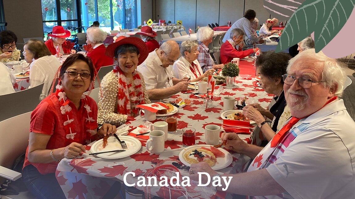 A group of seniors enjoying a healthy meal together on Canada Day in Wisteria Place senior living
