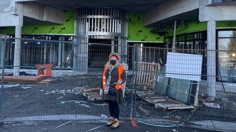 A construction lady standing outside a building under development