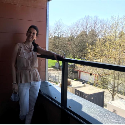 A picture of a lady standing at a balcony in senior apartments