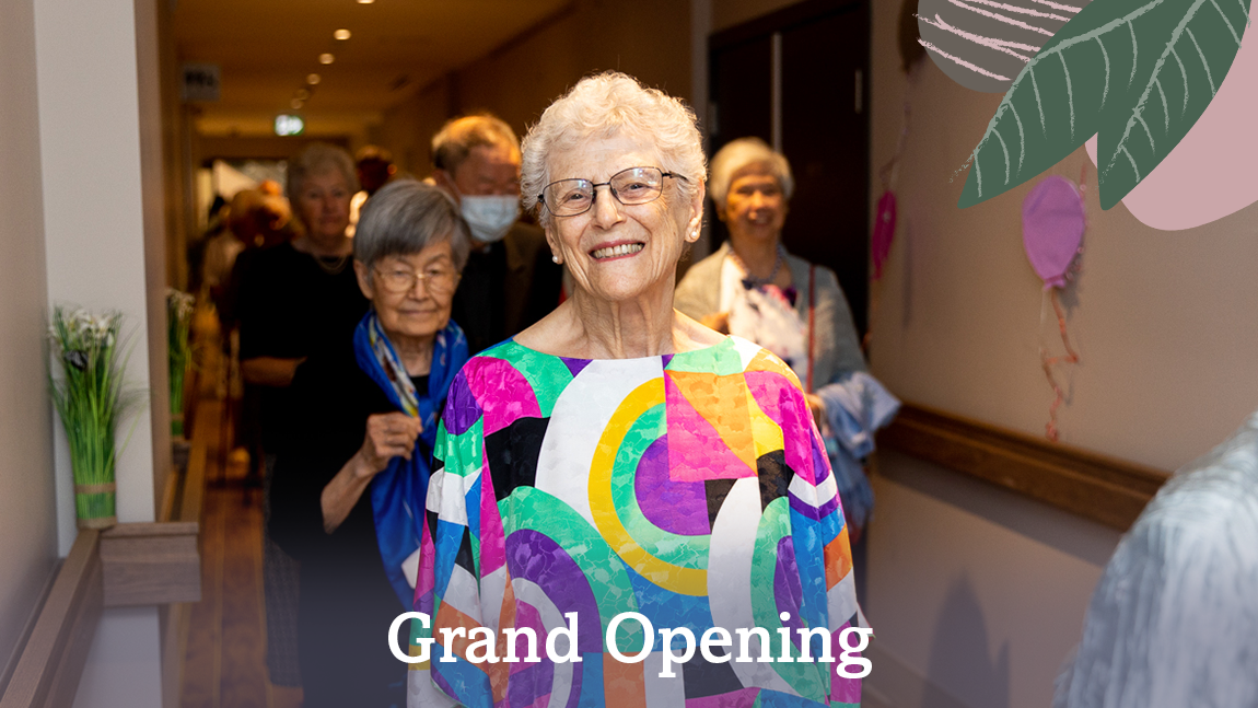 Grand opening header for Wisteria Place retirement home that features a parade of smiling seniors. The woman in the front of the group is in a bright and colourful shirt covered in squares and circles.