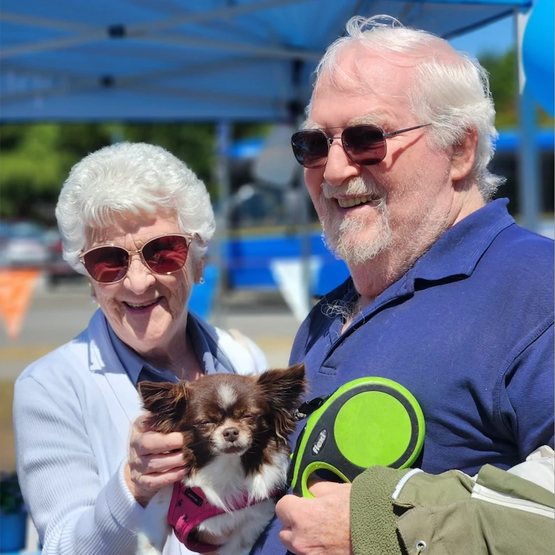 Two seniors at the Farmer's Market with a cute little dog