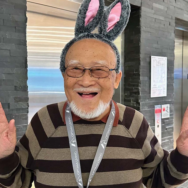Senior smiling and posing with some bunny ears on his head