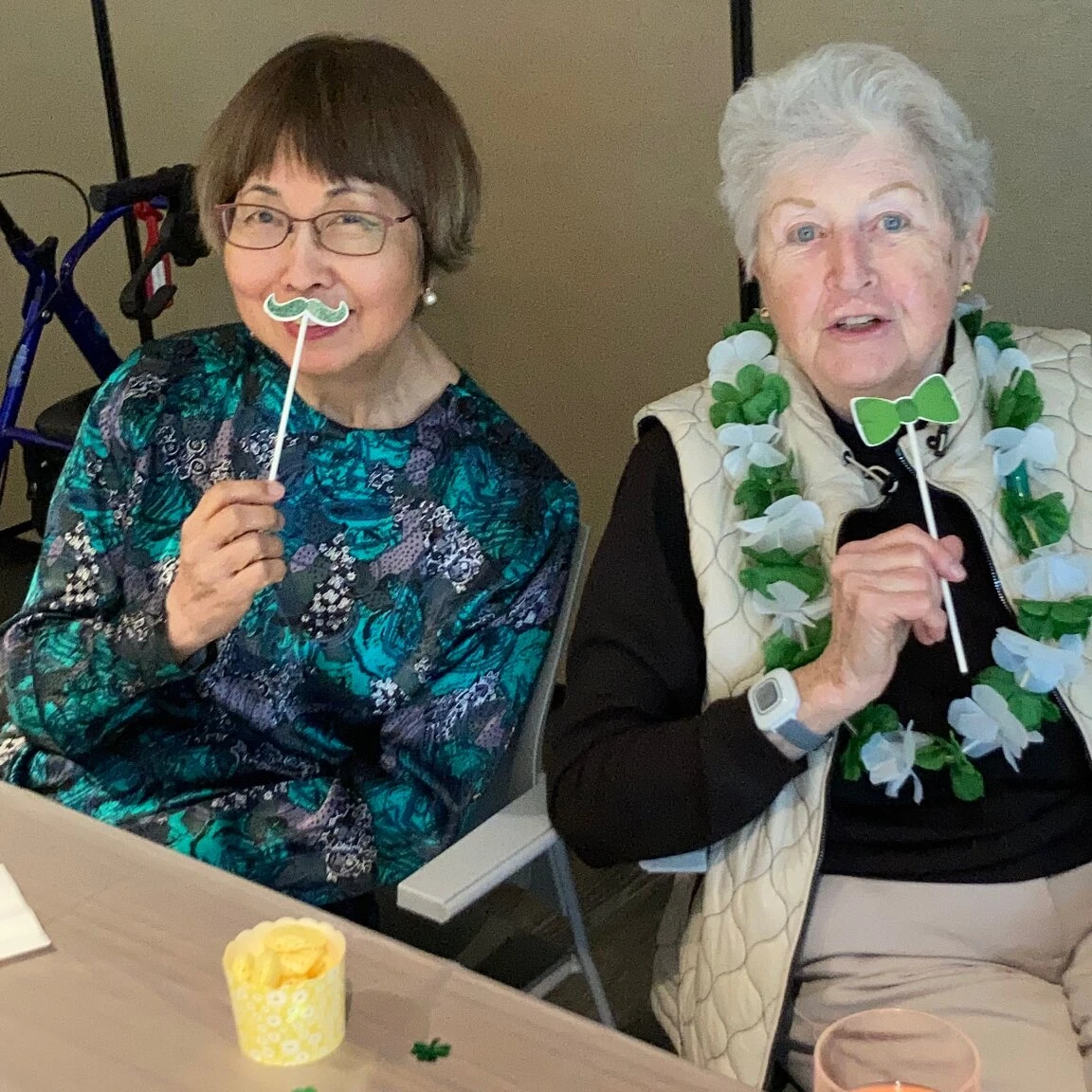 Two elderly ladies celebrating St. Patrick's Day at their senior home