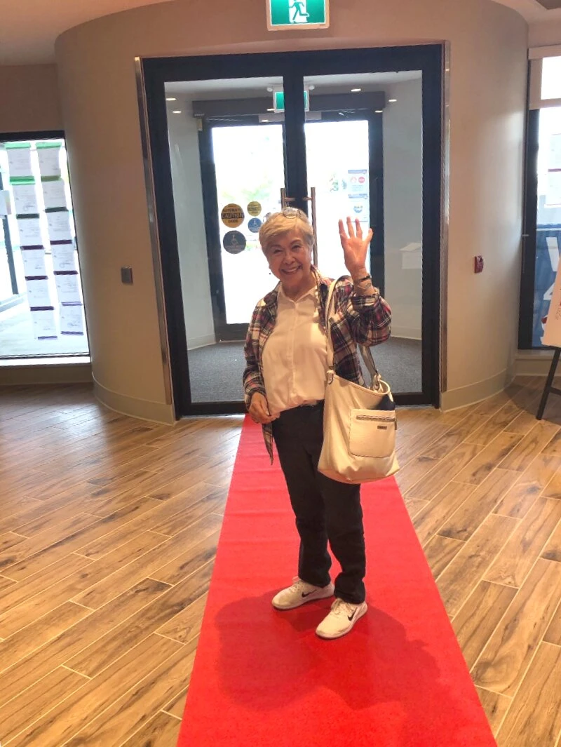 A lady standing on red carpet inside independent living for seniors