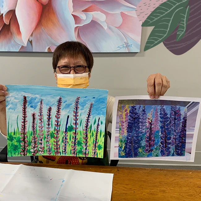 An elderly lady showing her paintings, fun activities for seniors