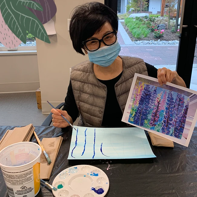 An elderly lady showing her painting, fun activities for seniors
