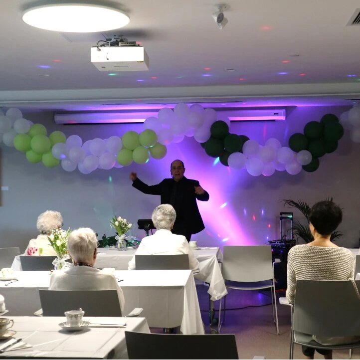 A man speaking in a public event at Wisteria Place elderly care home
