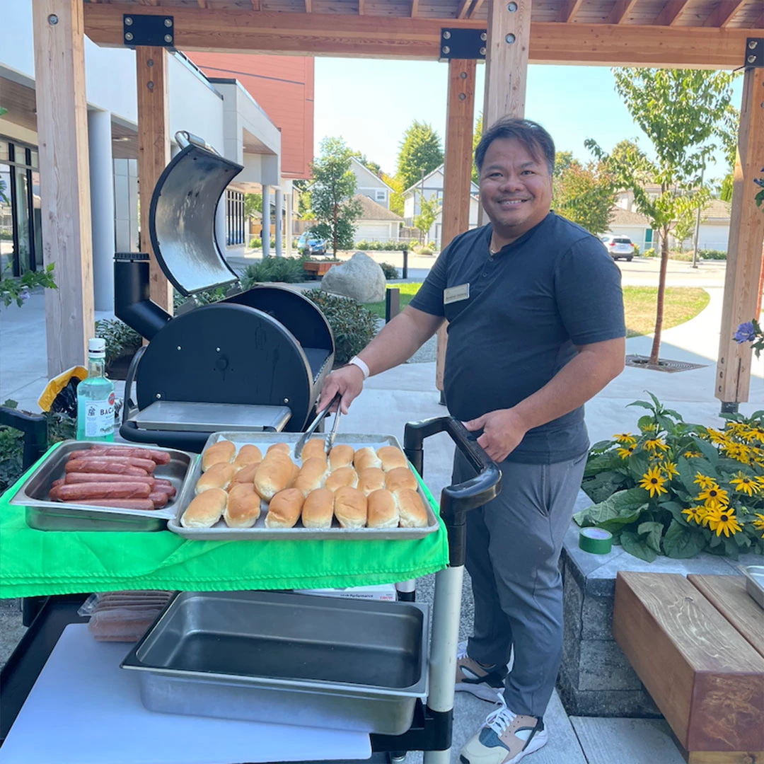 Chef cooking some hot dogs on the BBQ