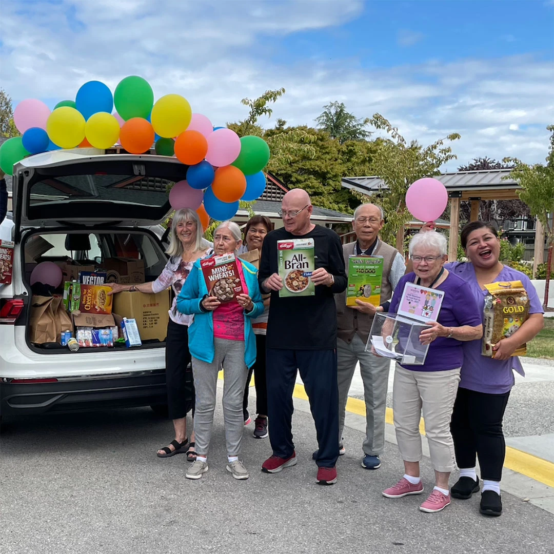 Senior residents standing with food bank donations