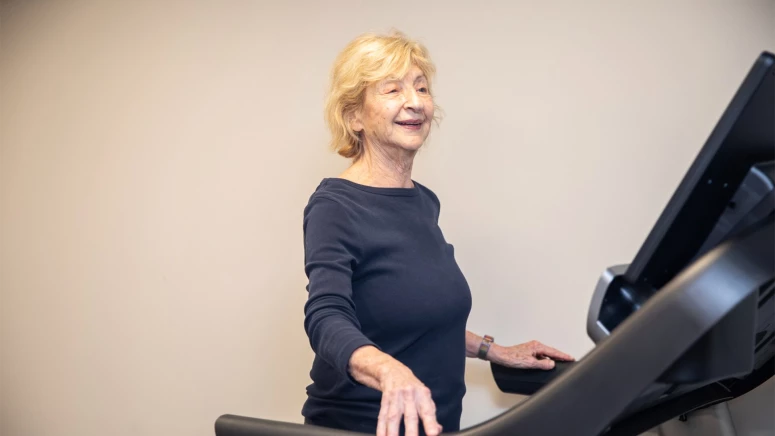 A senior woman walking on a treadmill