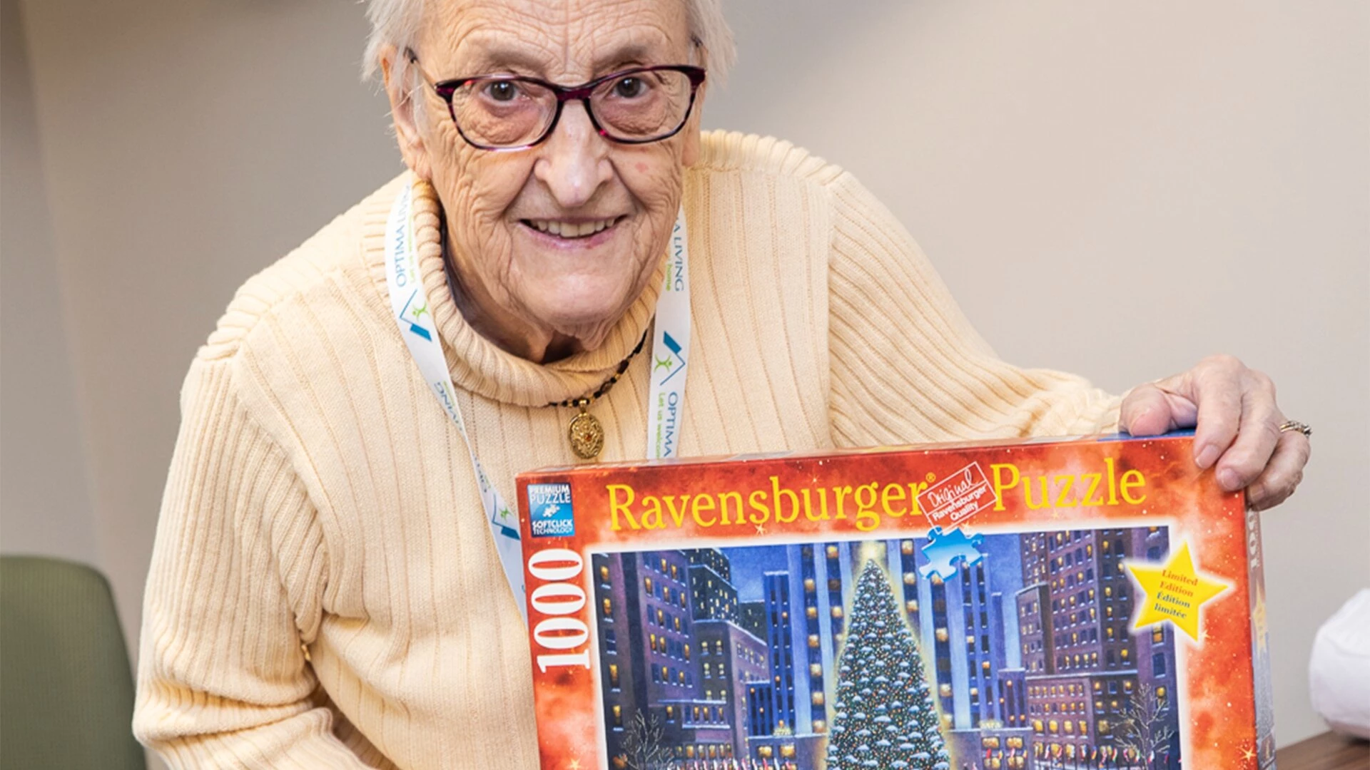 An elderly woman holding a puzzle box in her retirement home