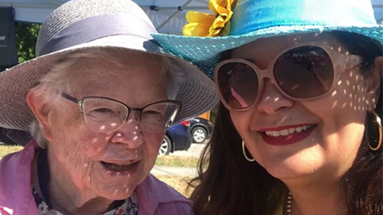 Two seniors dressed for summer at a senior living community booth