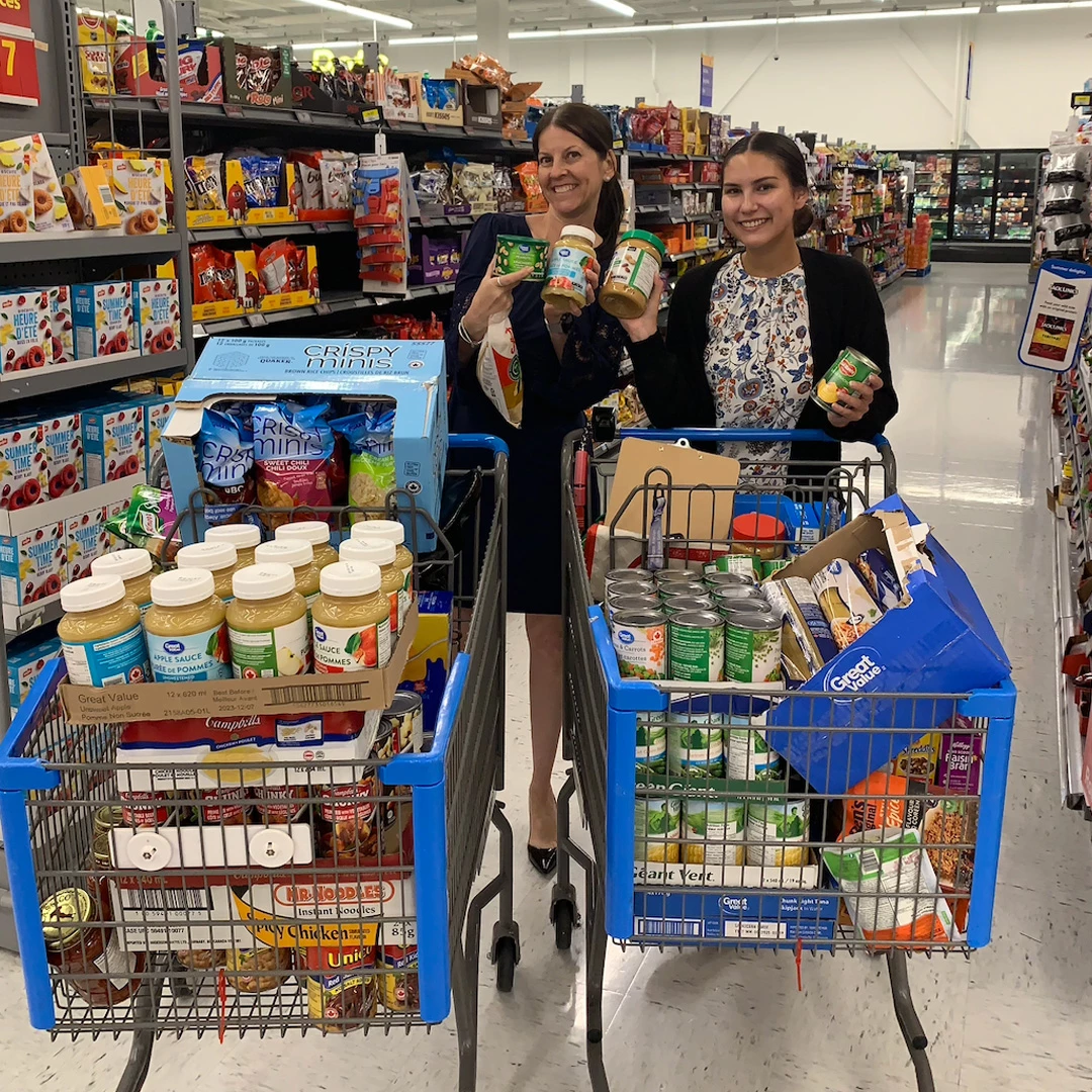 Two young ladies doing shopping for food bank day in grocery store