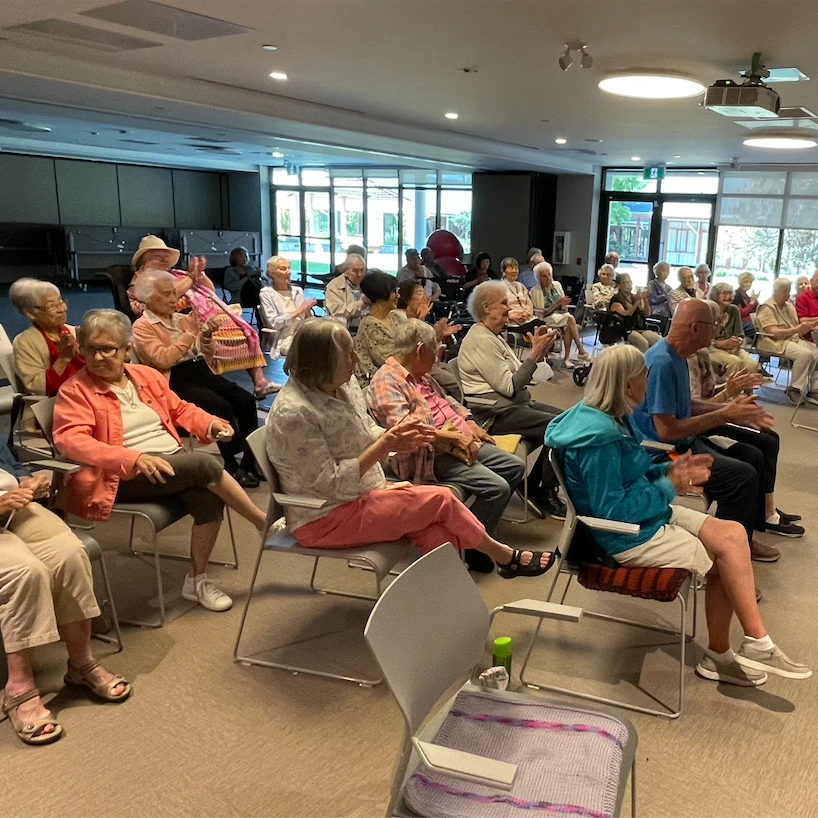 Seniors listening to a musical performance during happy hour