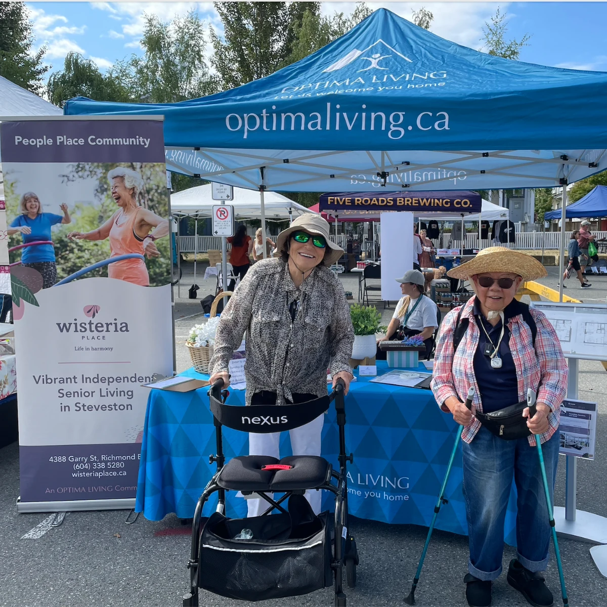 Seniors smiling at the Wisteria Place booth in the farmer's market