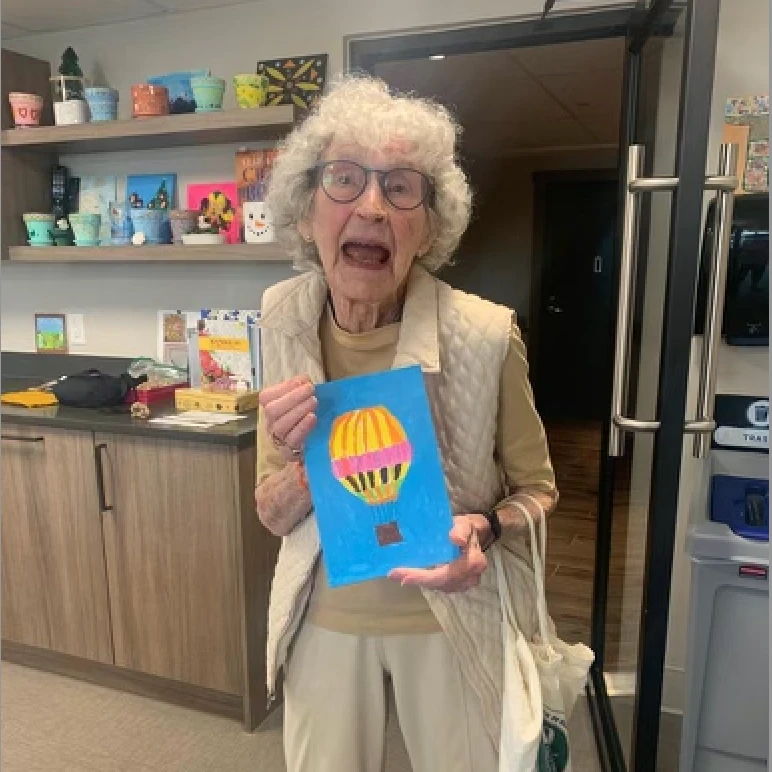 Senior standing with her painting